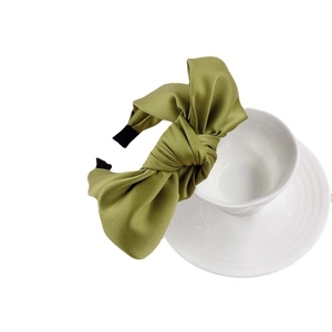 Elegant olive green satin bow headband featuring a wide design and smooth silk texture