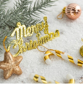 Close-up of golden Merry Christmas signs, glitter stars, and candy cane tree decorations