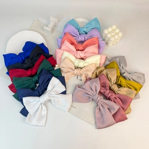 Close-up of premium satin bow hair clips in multiple colors on a clean white background