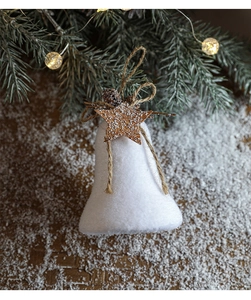 Close-up of white flocked Christmas bell with a pine cone and star on a snowy background