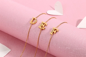 Detailed close-up of gold D, E, F letter necklaces with sparkling crystal pavé accents
