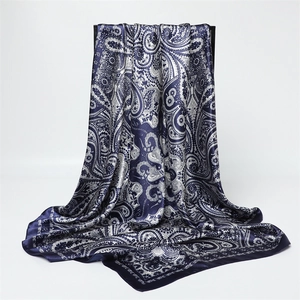Gros plan détaillé du foulard en satin cachemire bleu marine avec texture soyeuse et motifs