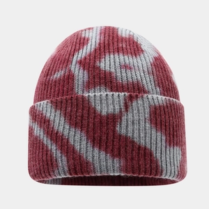 Detail of winter ribbed beanie featuring a burgundy tie-dye pattern and thick knit texture