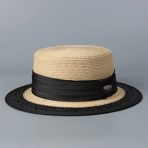 Detail of boater hat straw texture with wide black satin ribbon and metal logo