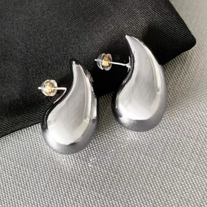 Polished silver teardrop earrings with a minimalist 18K gold-plated geometric design
