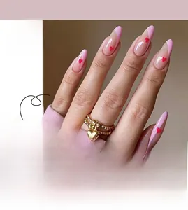 Detail of almond press-on nails featuring pink French tips and small red hearts