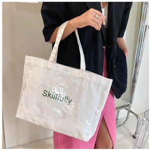 Detail of white canvas tote bag with green Skillfully print and waterproof outer layer