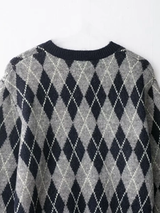 Detail view of the classic argyle knit pattern sweater in navy, grey, and white tones