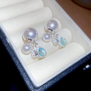 Macro shot of French luxury style pearl earrings with blue gemstone in a jewelry box