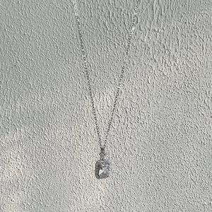 Detail of S925 silver necklace featuring a rectangular zircon pendant and small crystals