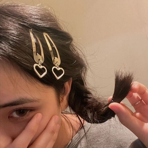Golden heart pendant metal hair clips shown on a model for a stylish girl hair accessory