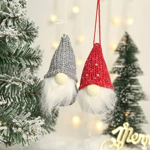 Pair of hanging Christmas gnomes with knitted hats and plush beards on a festive background