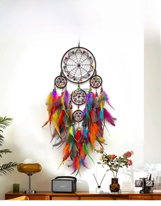 Detail of multi-ring rainbow dream catcher with colorful feathers on a white wall decor
