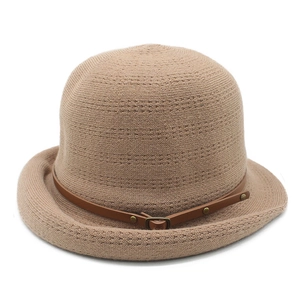 Détail d'un chapeau cloche en tricot kaki avec une ceinture en cuir marron et boucle