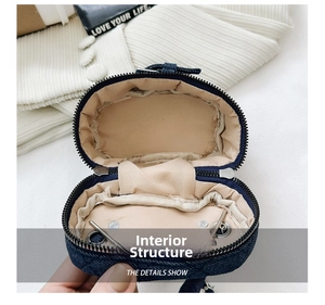 Macro internal view of blue denim mini bag with textile lining and black zipper detail
