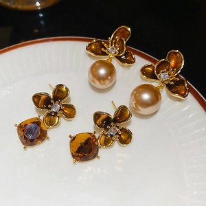 Macro detail of 18K gold plated flower earrings with champagne pearls and amber gemstones