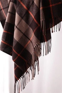 Detailed view of the plaid scarf showing brown and beige weave with soft fringe edges