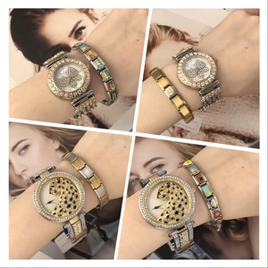 Detail of luxury gold-plated watch and charm bracelet set with crystal bezel and leopard motif