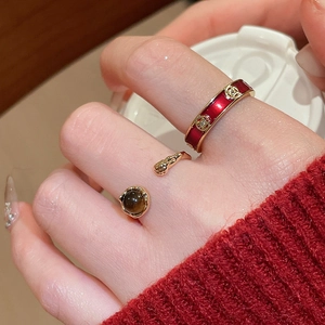 Detail of 18k gold plated tiger eye stone ring and red enamel band on hand