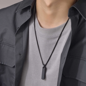 Men's black vertical bar necklace in stainless steel shown on a model over a grey shirt