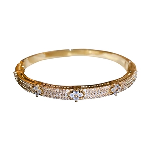 Golden flower bangle with cubic zirconia pavé setting on a minimalist metal band