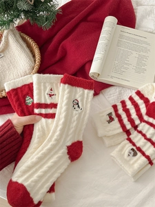 Detail of red and white Christmas socks with embroidered snowman and reindeer motifs