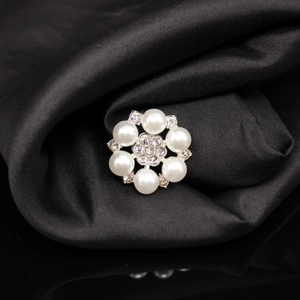 Macro detail of alloy flower button with six white pearls and sparkling rhinestones