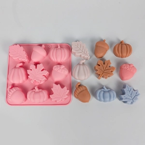 Detail view of 12-hole pink silicone mold with pumpkin, leaf, and acorn shapes for DIY baking