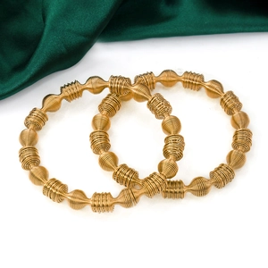 Gold plated stainless steel elastic spring bracelets with silk texture on white background