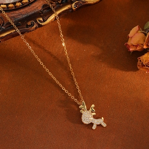 Close-up of golden reindeer pendant with full diamond pavé on warm vintage background