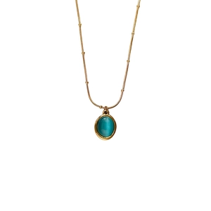 Titanium steel gold necklace with an oval blue cat-eye stone pendant on a white background