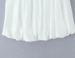 Detailed close-up of white pleated bubble hem with a voluminous puff design