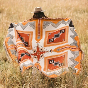 Bohemian style woven picnic blanket with geometric patterns and fringe for outdoor camping