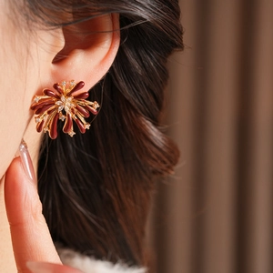 Gros plan de boucles d'oreilles fleurs bordeaux élégantes avec zircone sur un mannequin