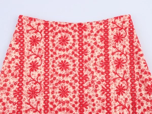 Detailed close-up of red floral embroidery and hollow-out lace patterns on the mini skirt