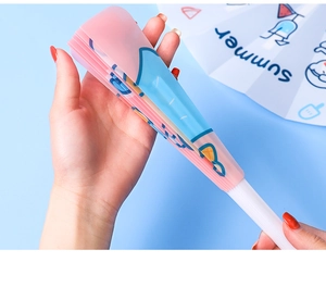 Folded pink handheld fan with Summer text held against a light blue background