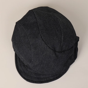 Top-down view of a black denim newsboy cap featuring classic pleated six-panel construction
