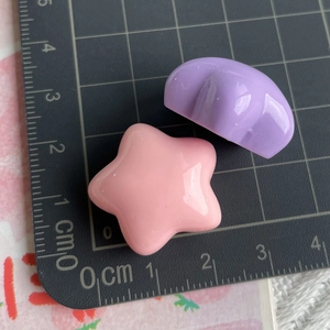 Macro view of 2cm star-shaped resin charms on a measuring mat for DIY crafts