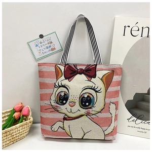 Detailed view of canvas tote bag featuring striped pattern and embroidered cartoon cat