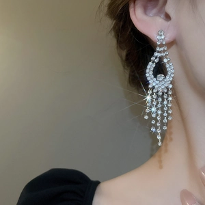 Close-up of sparkling floral diamond tassel earrings on a model with elegant silver finish