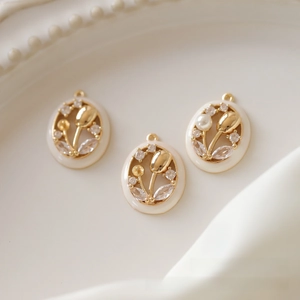 Detail of gold-plated tulip charms with white enamel and sparkling zircon accents