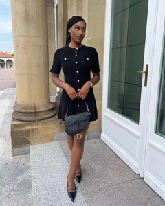 Detail view of a black knit dress on a model in a classic architectural setting