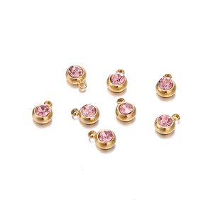 Détail de sept pendentifs de 6mm en acier inoxydable doré avec zircons rose pierre