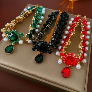 Vintage style necklace with red black green gems and pearls on a golden metal base