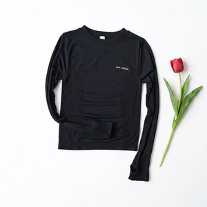 Détail du haut de sport noir sans couture avec panneaux en maille et logo