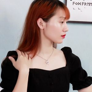 Halskette mit silbernem Herzanhänger und Zirkonia am Model mit schwarzem Kleid