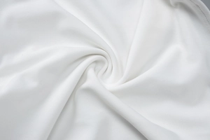 Close-up of premium white knitted fabric texture showing soft drape and fine weave detail