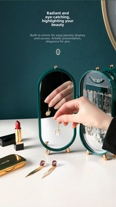 Detail of dark green jewelry organizer with mirror, hooks and transparent compartments