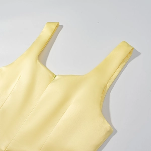 Detailaufnahme des gelben Satin-Kleids mit quadratischem Ausschnitt und Reißverschluss