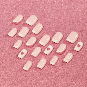 Pink heart press-on nails with French white tips and glitter details in mid-length